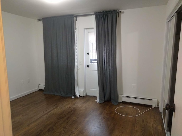 foyer entrance featuring a baseboard heating unit, wood finished floors, and a baseboard radiator