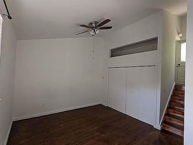 unfurnished bedroom with dark wood-type flooring, baseboards, and a ceiling fan