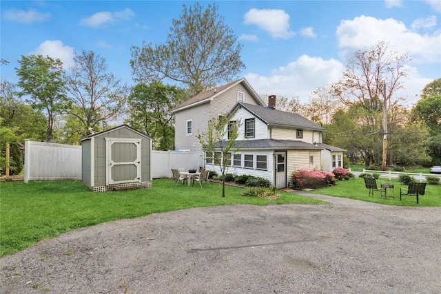 35 Fallkill Ave, Poughkeepsie, NY 12601 - back of house featuring a storage unit, a chimney, an outdoor structure, and roof with shingles