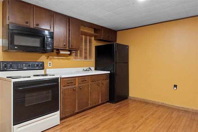 35 Fallkill Ave, Poughkeepsie, NY 12601 - kitchen featuring black appliances, light wood-style flooring, light countertops, baseboards, and a sink