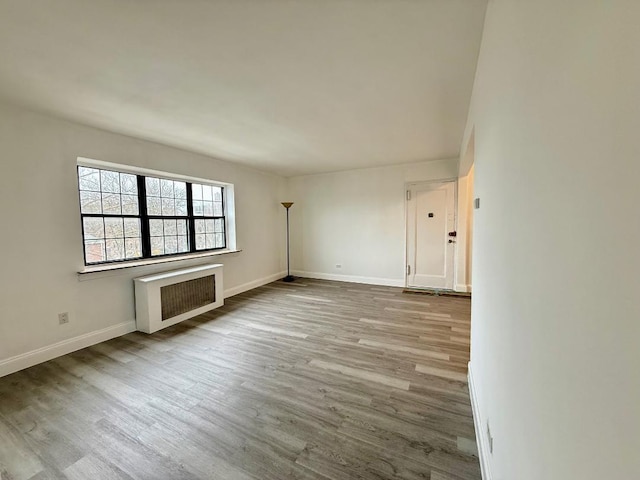 78-16 147th St # # 3C, Flushing, NY 11367 - empty room featuring wood finished floors, baseboards, and heating unit