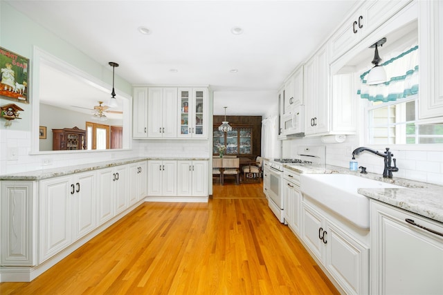 68 Forest Dr, Poughquag, NY 12570 - kitchen featuring white appliances, decorative backsplash, a sink, white cabinetry, and hanging light fixtures