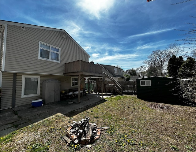 275 Beachview St, Copiague, NY 11726 - rear view of house featuring a patio, stairway, an outdoor fire pit, an outdoor structure, and a storage shed