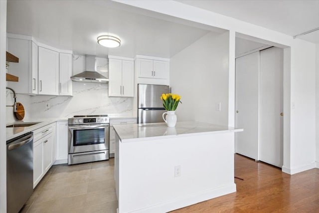 50 Columbus Ave Unit 605, Tuckahoe, NY 10707 - kitchen featuring stainless steel appliances, wall chimney exhaust hood, decorative backsplash, a sink, and white cabinets