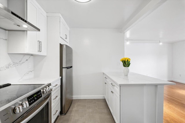 50 Columbus Ave Unit 605, Tuckahoe, NY 10707 - kitchen with appliances with stainless steel finishes, wall chimney exhaust hood, a peninsula, light stone counters, and white cabinets