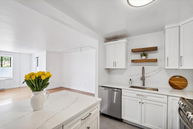 50 Columbus Ave Unit 605, Tuckahoe, NY 10707 - kitchen featuring stainless steel appliances, a sink, open shelves, light stone counters, and white cabinets