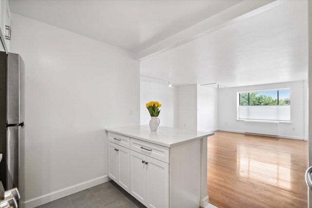 50 Columbus Ave Unit 605, Tuckahoe, NY 10707 - kitchen with a peninsula, freestanding refrigerator, light stone counters, white cabinets, and open floor plan