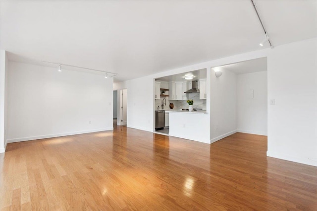 50 Columbus Ave Unit 605, Tuckahoe, NY 10707 - unfurnished living room featuring track lighting, light wood-type flooring, a sink, and baseboards