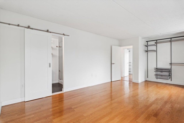 50 Columbus Ave Unit 605, Tuckahoe, NY 10707 - unfurnished bedroom featuring wood finished floors, a barn door, and baseboards