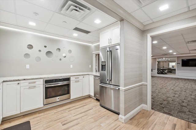 50 Columbus Ave Unit 605, Tuckahoe, NY 10707 - kitchen with stainless steel appliances, a drop ceiling, white cabinets, light stone countertops, and light wood finished floors