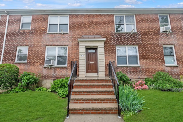 204-08 35th Ave Unit 247, Bayside, NY 11361 - view of front facade featuring a front lawn, cooling unit, and brick siding