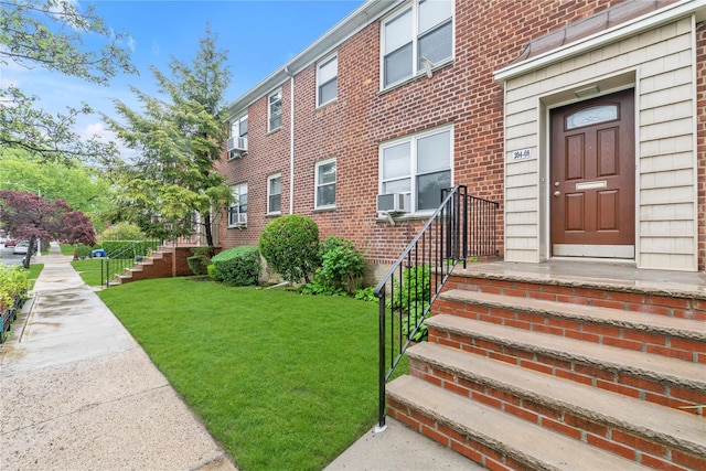 204-08 35th Ave Unit 247, Bayside, NY 11361 - doorway to property with a yard, brick siding, and cooling unit