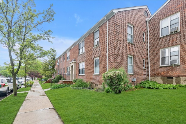 204-08 35th Ave Unit 247, Bayside, NY 11361 - view of property exterior featuring brick siding, a yard, and cooling unit