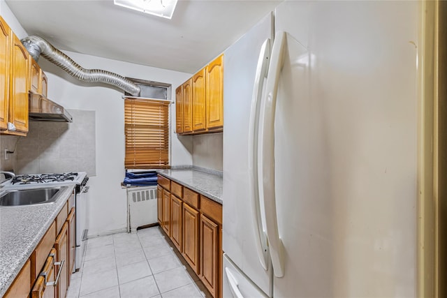 144-44 38th Ave Unit 6G, Flushing, NY 11354 - kitchen with freestanding refrigerator, under cabinet range hood, radiator, stainless steel gas range oven, and decorative backsplash