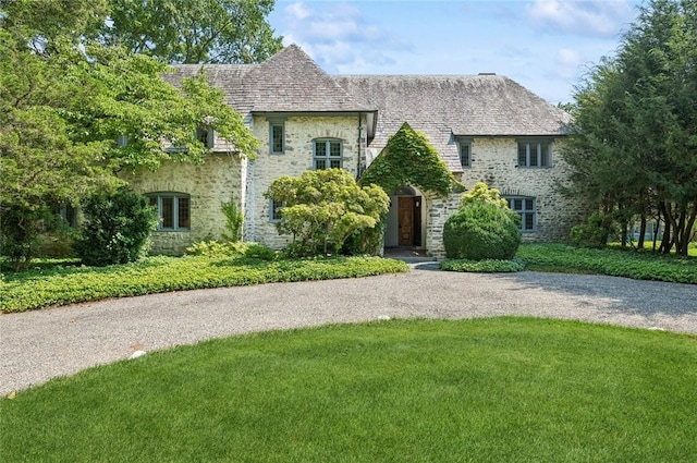 3 Loden Ln, Purchase, NY 10577 - view of front of house with stone siding, a front lawn, and a high end roof