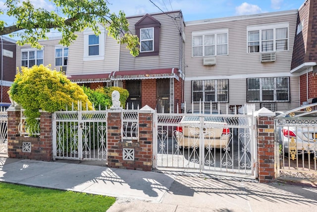154-04 107th Ave, Jamaica, NY 11433 - multi unit property with a fenced front yard, brick siding, a gate, an AC wall unit, and a wall unit AC