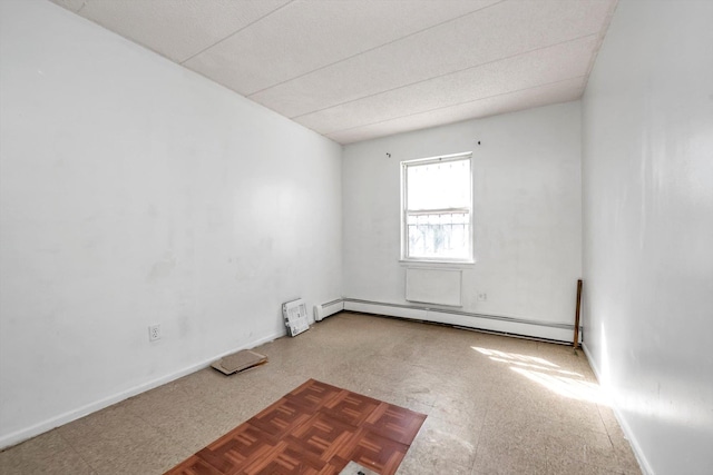 154-04 107th Ave, Jamaica, NY 11433 - spare room featuring a baseboard heating unit, tile patterned floors, and baseboards