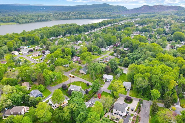 aerial view of residential area with a water and mountain view and a heavily wooded area