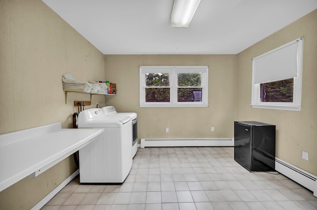 laundry room featuring baseboard heating, washing machine and clothes dryer, light flooring, and baseboards