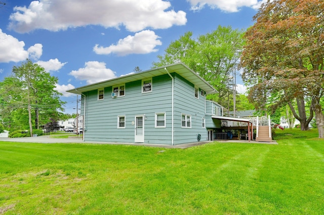 back of house with a lawn, a wooden deck, and stairs