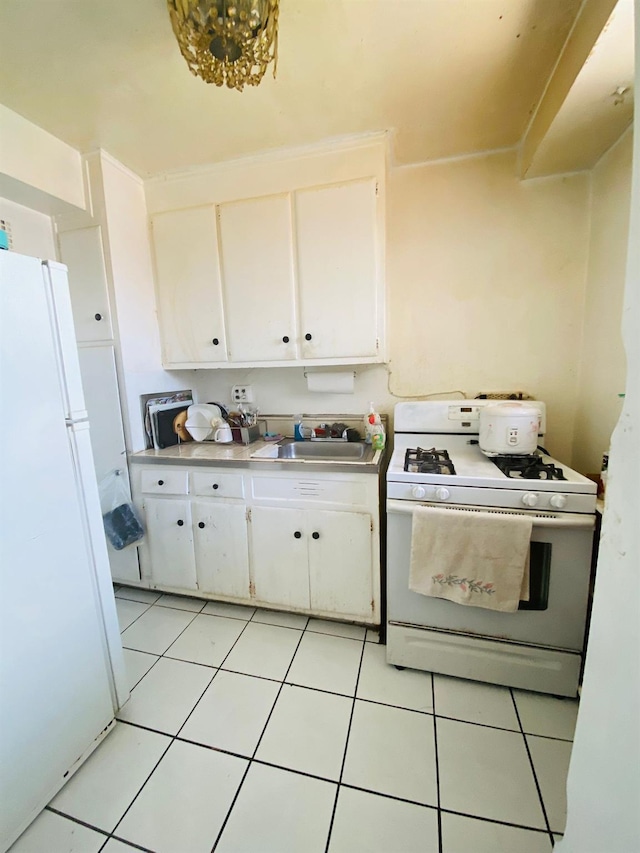 kitchen featuring white appliances, a sink, white cabinets, light countertops, and light tile patterned floors