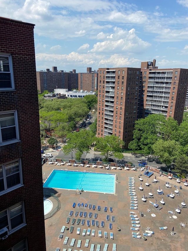 community pool with a patio and a view of city