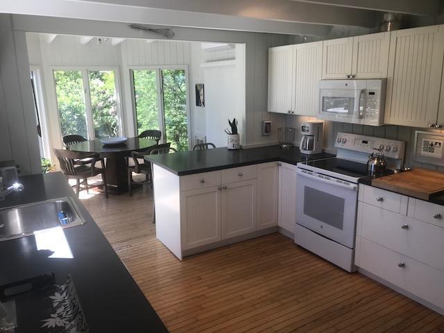 209 Bayview Walk, Cherry Grove, NY 11782 - kitchen featuring white appliances, a peninsula, light wood-style floors, a sink, and white cabinetry