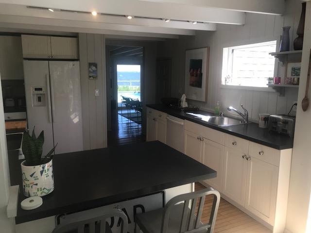 209 Bayview Walk, Cherry Grove, NY 11782 - kitchen with white refrigerator with ice dispenser, dark countertops, a sink, dishwashing machine, and beam ceiling