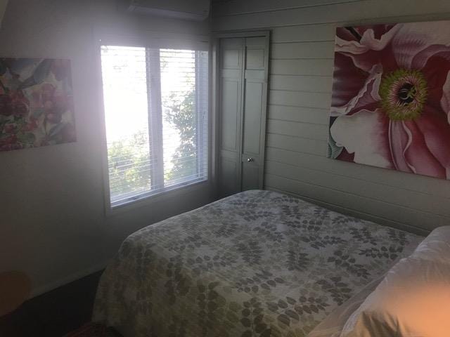 209 Bayview Walk, Cherry Grove, NY 11782 - bedroom featuring a wall mounted AC and wood walls