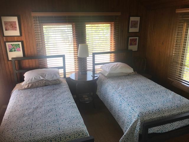 209 Bayview Walk, Cherry Grove, NY 11782 - bedroom featuring wood walls, multiple windows, and wood finished floors