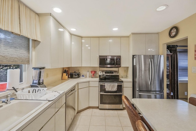 12 Grand Canyon Ln, Coram, NY 11727 - kitchen featuring appliances with stainless steel finishes, light countertops, light tile patterned floors, a sink, and cream cabinets