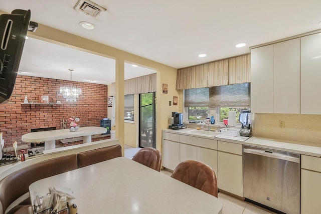 12 Grand Canyon Ln, Coram, NY 11727 - kitchen featuring dishwasher, a sink, brick wall, light countertops, and cream cabinetry