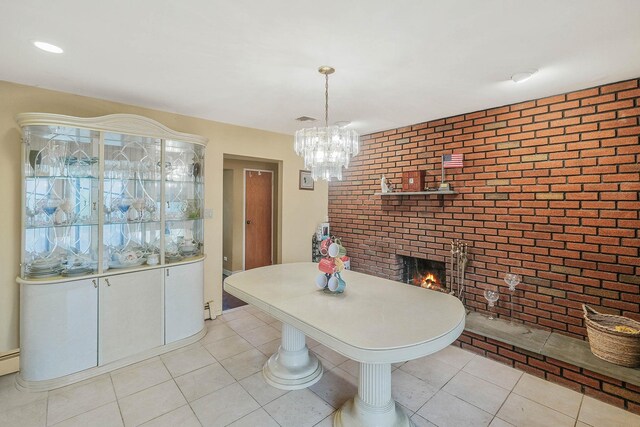 12 Grand Canyon Ln, Coram, NY 11727 - dining room with brick wall, a brick fireplace, light tile patterned floors, and a chandelier