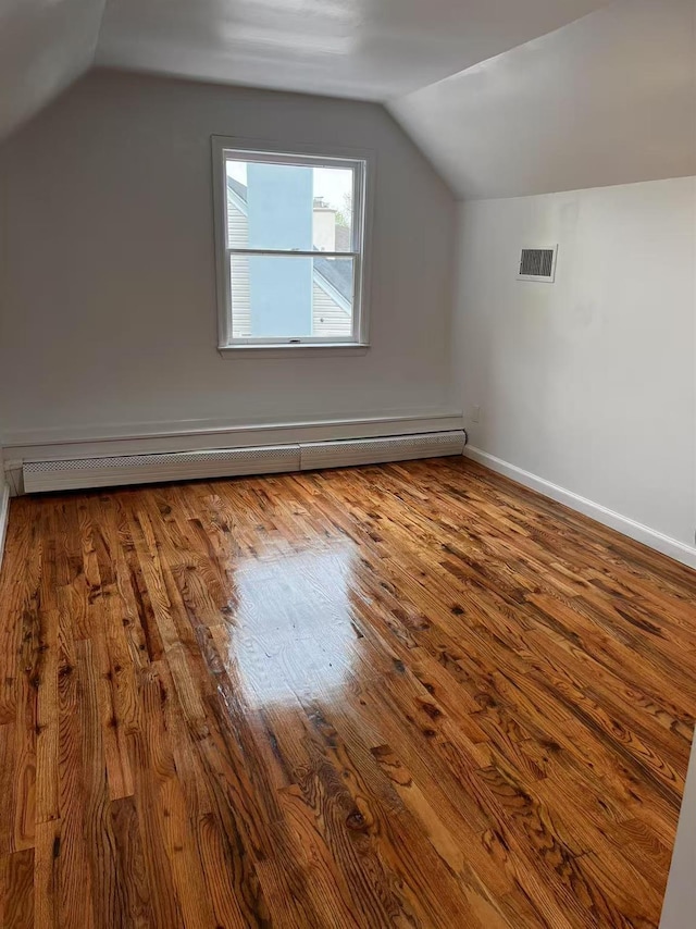 97 Hungry Harbor Rd, Valley Stream, NY 11581 - additional living space with baseboard heating, wood finished floors, lofted ceiling, and baseboards