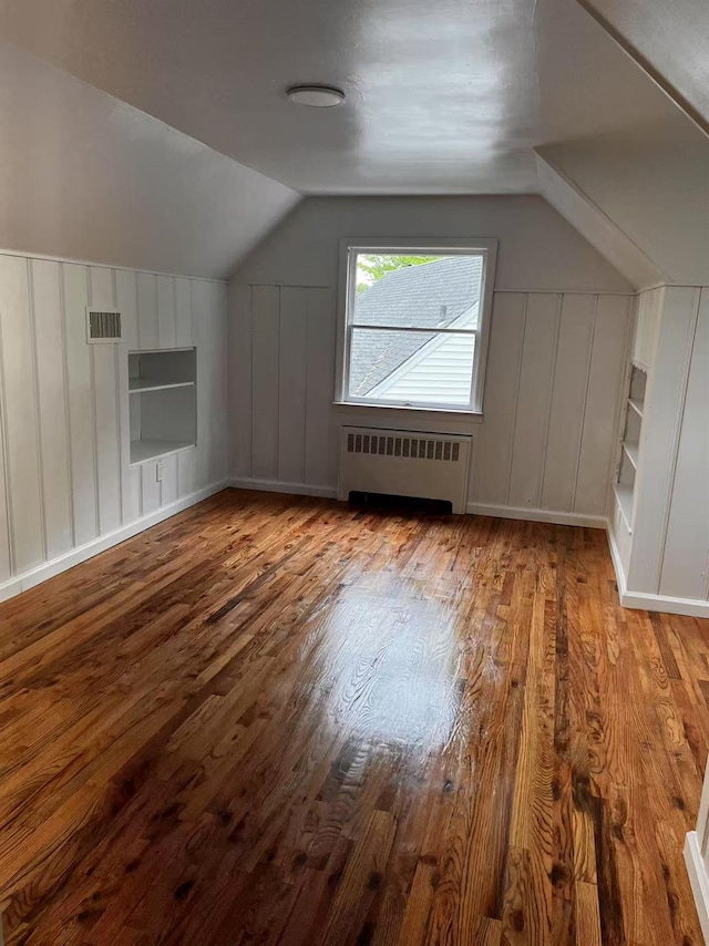 97 Hungry Harbor Rd, Valley Stream, NY 11581 - bonus room with radiator heating unit, a decorative wall, wood finished floors, and vaulted ceiling