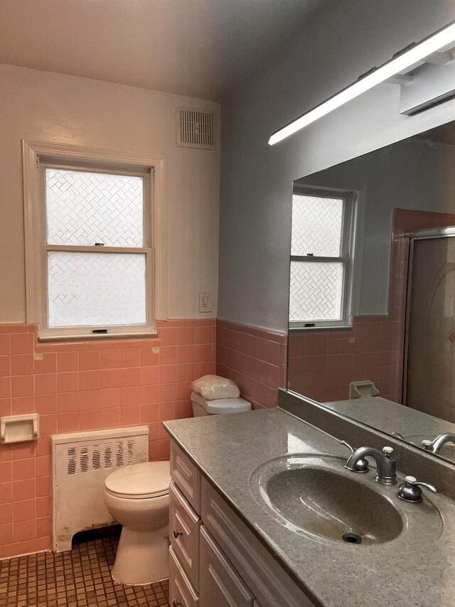 97 Hungry Harbor Rd, Valley Stream, NY 11581 - bathroom featuring radiator heating unit, tile walls, wainscoting, tile patterned flooring, and vanity