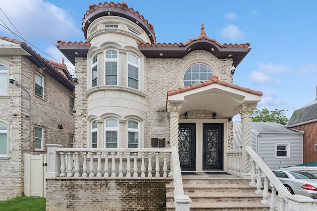 15007 Huron St, Ozone Park, NY 11417 - view of front facade with a tiled roof and covered porch