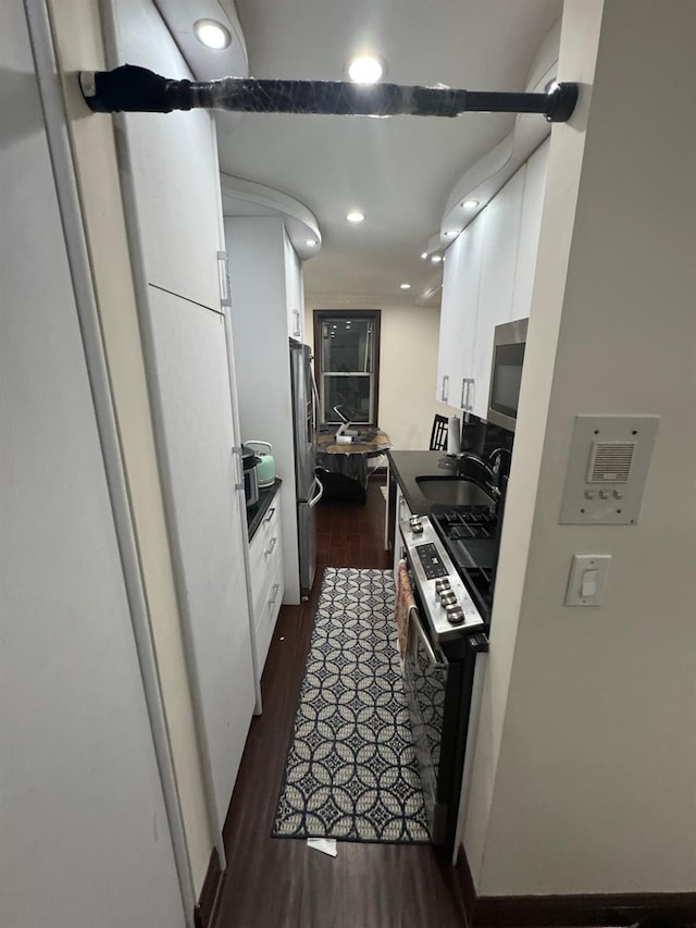 74-45 Yellowstone Blvd Unit 2A, Forest Hills, NY 11375 - kitchen featuring appliances with stainless steel finishes, a sink, white cabinets, dark wood finished floors, and recessed lighting