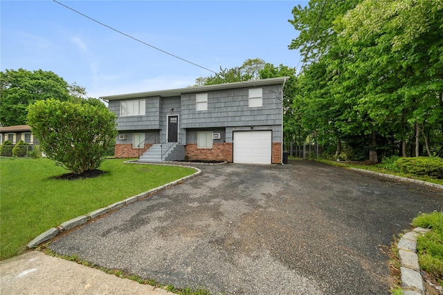 40 S 29th St, Wyandanch, NY 11798 - split foyer home featuring brick siding, asphalt driveway, a front lawn, and an attached garage