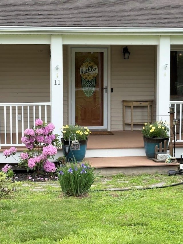 11 Queen Anne Ln, Wappingers Falls, NY 12590 - entrance to property featuring covered porch, roof with shingles, and a yard