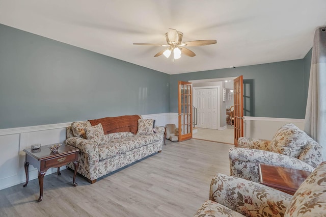 121 Tyler Ave, Miller Place, NY 11764 - living area featuring a ceiling fan, wainscoting, wood finished floors, and french doors