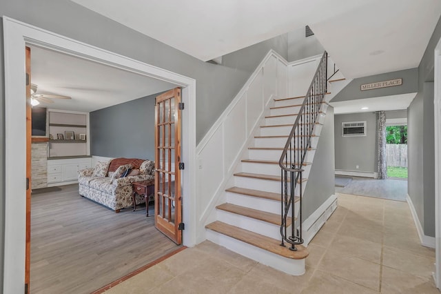 121 Tyler Ave, Miller Place, NY 11764 - stairs featuring a baseboard radiator, a ceiling fan, a wall mounted AC, wood finished floors, and baseboards