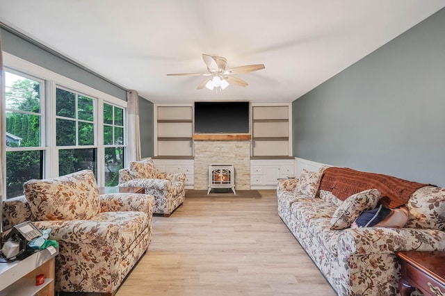 121 Tyler Ave, Miller Place, NY 11764 - living area with a ceiling fan, light wood finished floors, built in features, and a wood stove