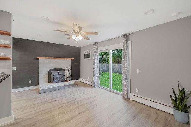 121 Tyler Ave, Miller Place, NY 11764 - unfurnished living room with baseboard heating, wood finished floors, a ceiling fan, and a wood stove