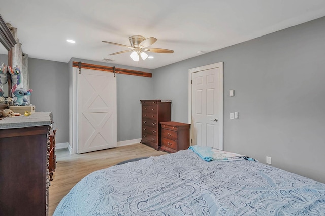 121 Tyler Ave, Miller Place, NY 11764 - bedroom with a barn door, light wood finished floors, ceiling fan, baseboards, and recessed lighting