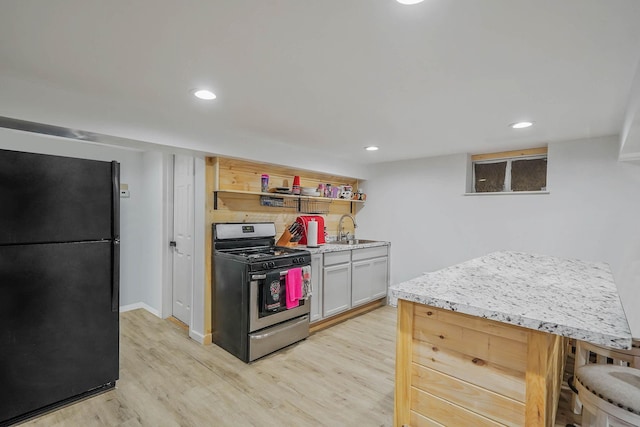 121 Tyler Ave, Miller Place, NY 11764 - kitchen featuring freestanding refrigerator, stainless steel range with gas stovetop, light wood-style flooring, a sink, and open shelves