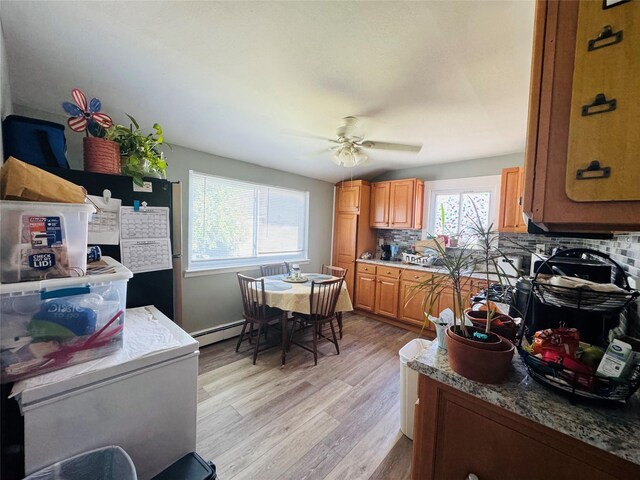 113 6th Ave, Huntington Station, NY 11746 - kitchen featuring backsplash, a ceiling fan, light wood-style floors, brown cabinets, and a baseboard radiator