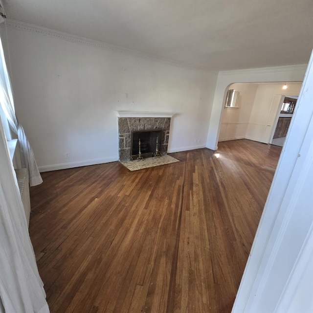 78-10 222nd St, Oakland Gardens, NY 11364 - unfurnished living room featuring hardwood / wood-style floors, a fireplace, ornamental molding, baseboards, and arched walkways