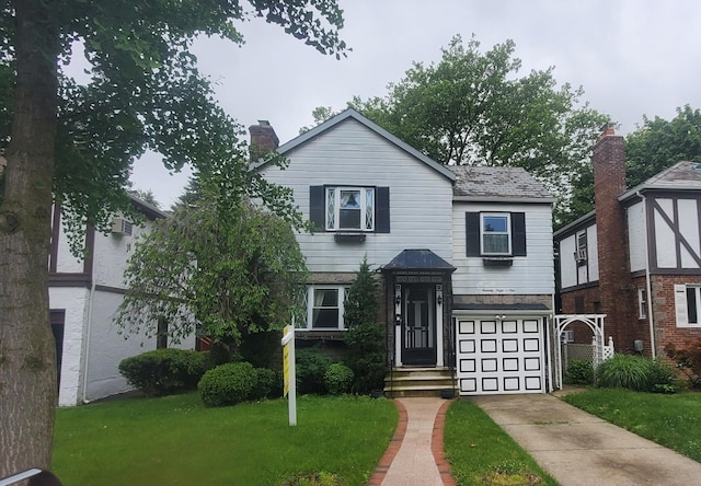 78-10 222nd St, Oakland Gardens, NY 11364 - view of front of home with concrete driveway, an attached garage, a chimney, and a front lawn