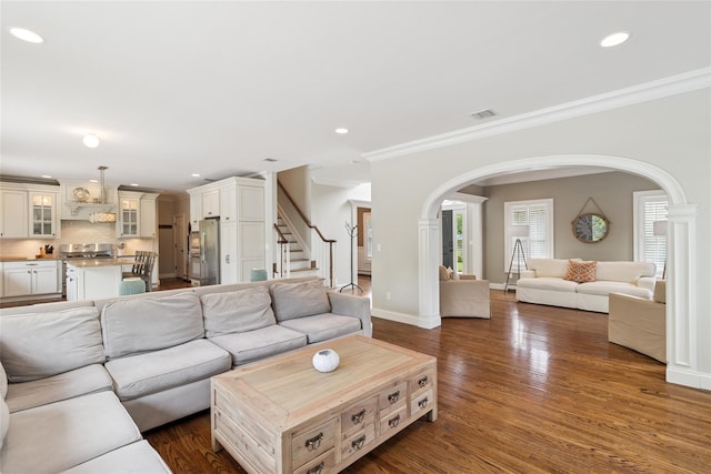 38 Savanna Cir, Mount Sinai, NY 11766 - living area with arched walkways, dark wood finished floors, recessed lighting, ornamental molding, and stairs